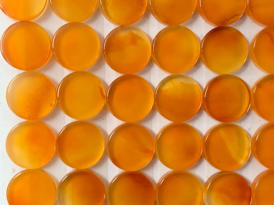 a grid of numerous circular objects, all of which are orange in color. The objects appear to be made of a material that resembles glass or a similar translucent material. The objects are arranged in a grid-like pattern, creating a visually striking and organized display.